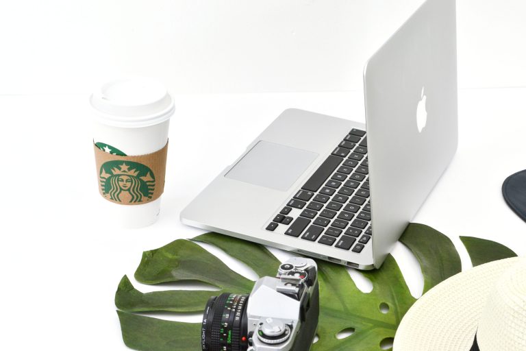 Macbook computer with camera and Starbucks coffee cup